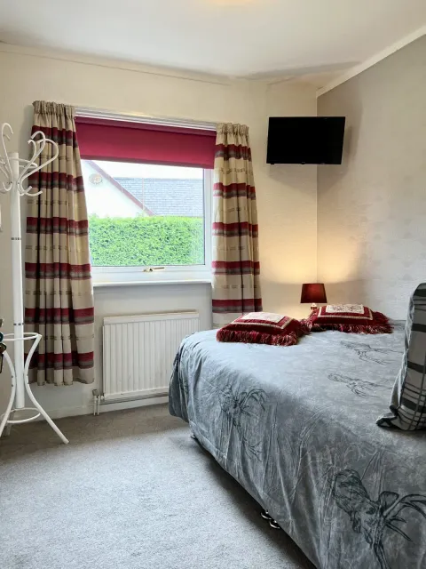Room 5, the bed and red curtains